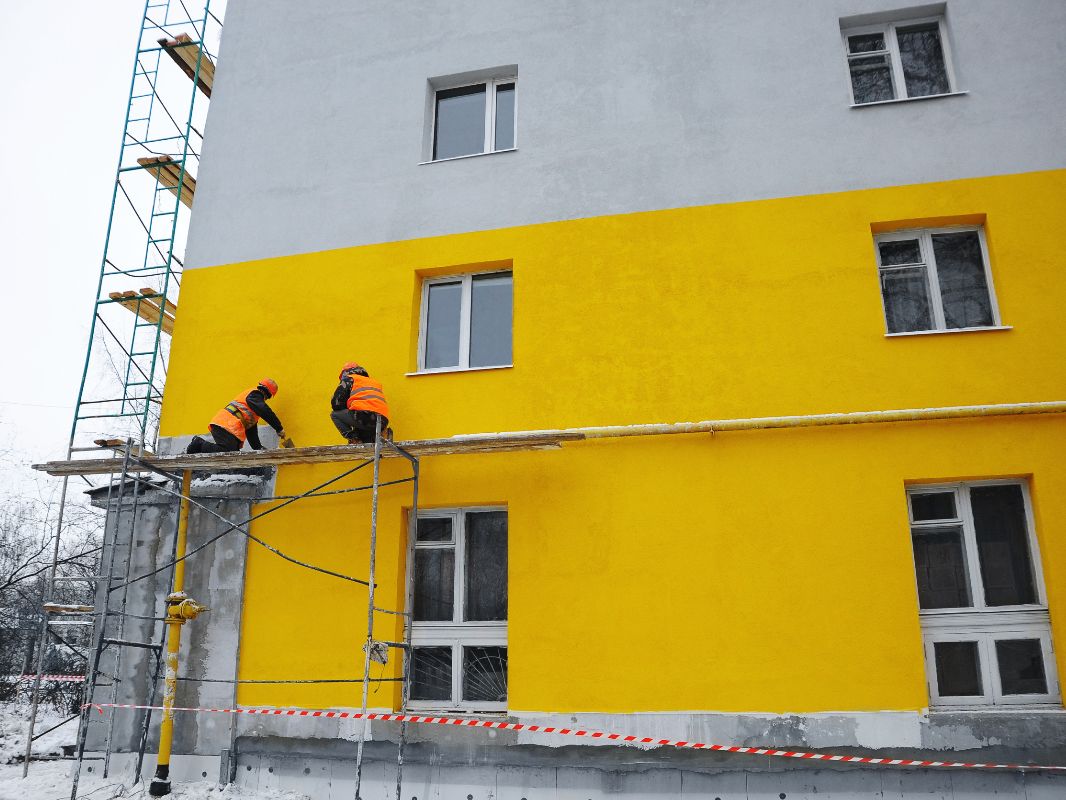 Obreros reparando fachada de edificio